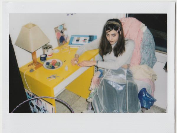 brooke sitting at their desk painting their nails. 