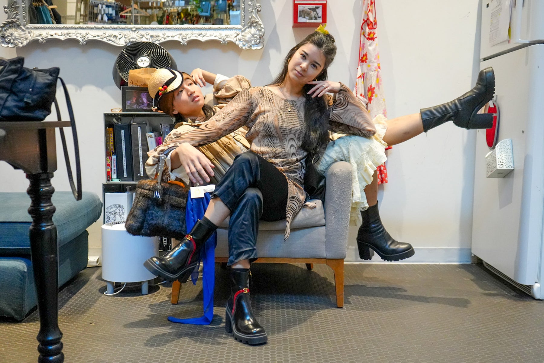 thanh and leah sharing a chair in the kitchen. 