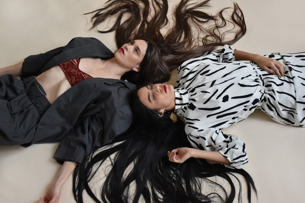 two models laying down with their long hair everywhere.