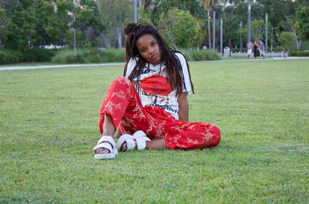 person with red pants sitting at grass. 
