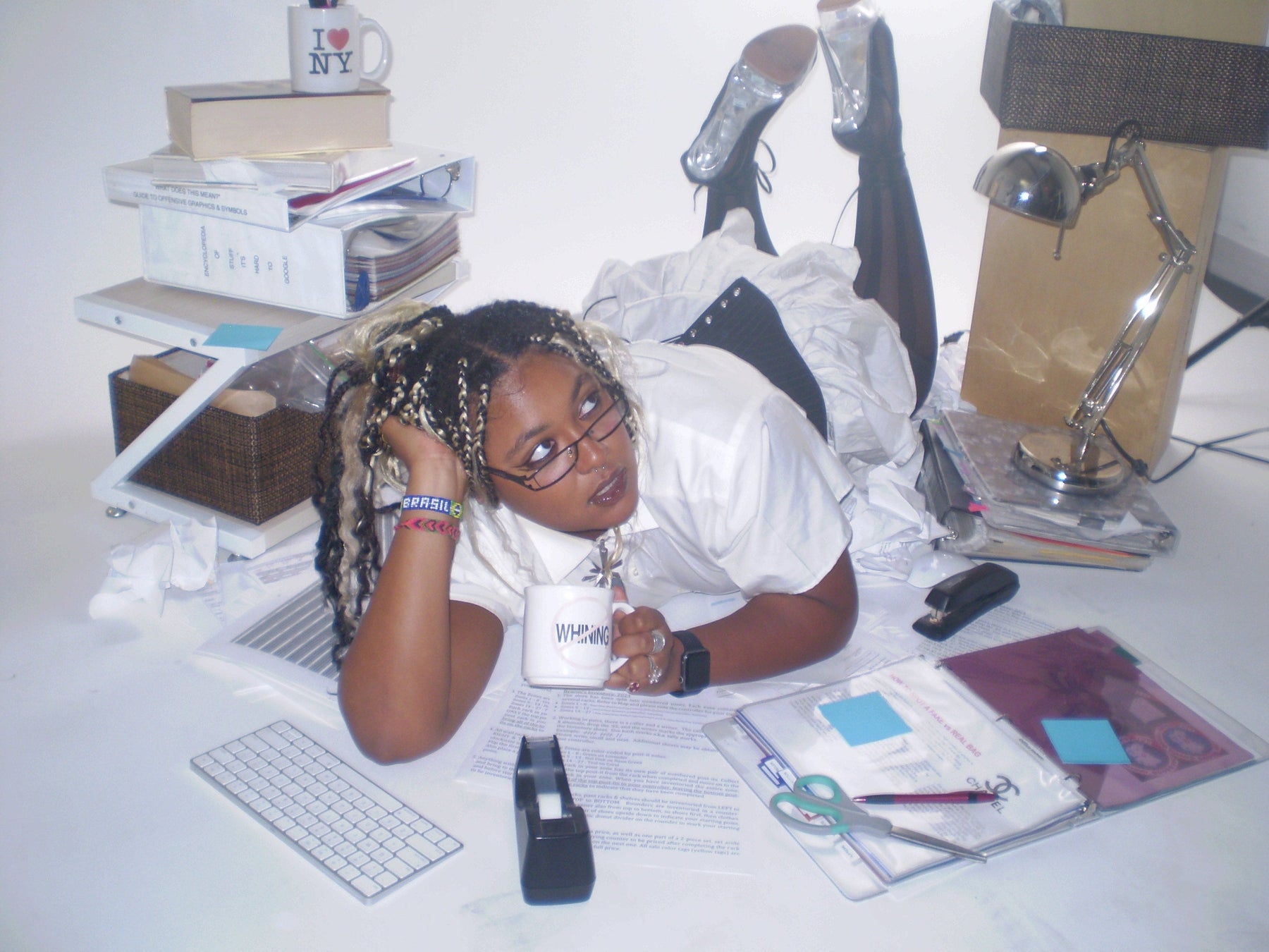 fun office siren editorial image of model laying amongst office supplies