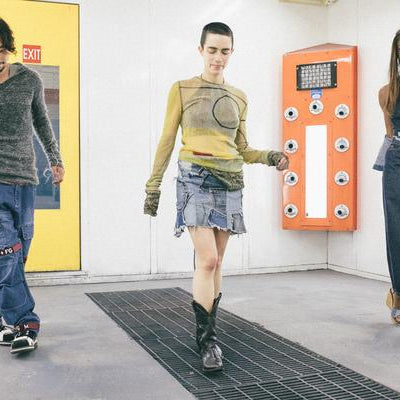 three models walking in car painting room.