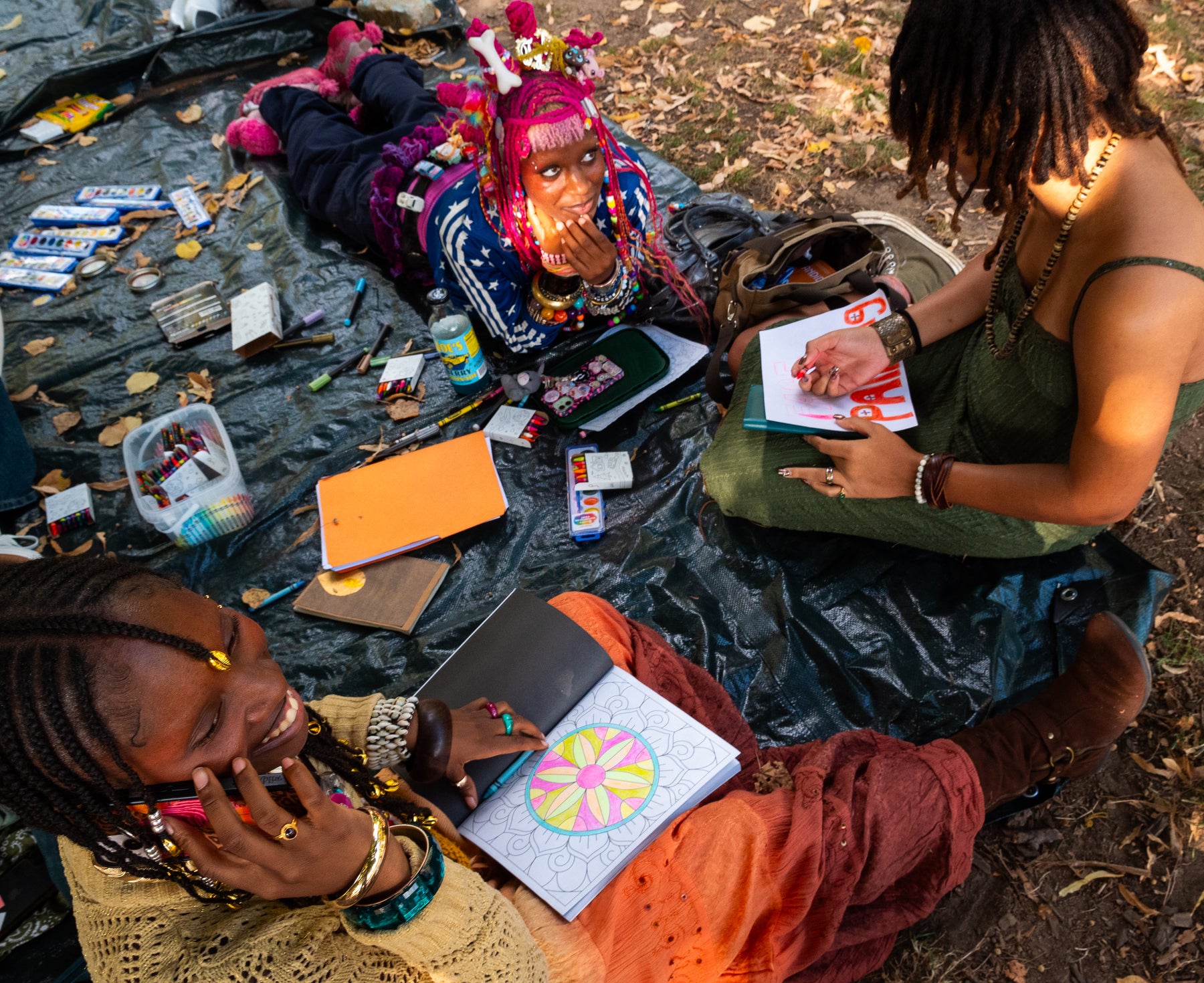 fetsival attendees sitting on blanket drawing at pow fest