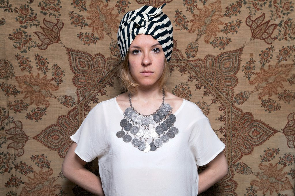 julia wearing a turban in front of a wall.