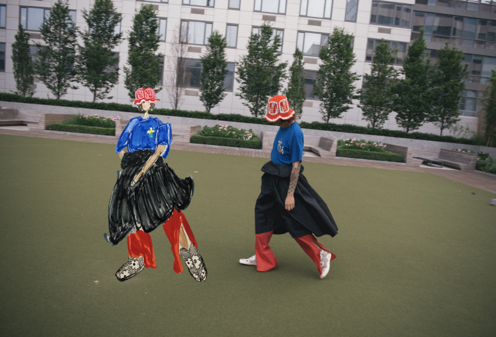 rao in city park in t-shirt, skirt, pants, and crochet bucket hat with drawn rendering of themself.