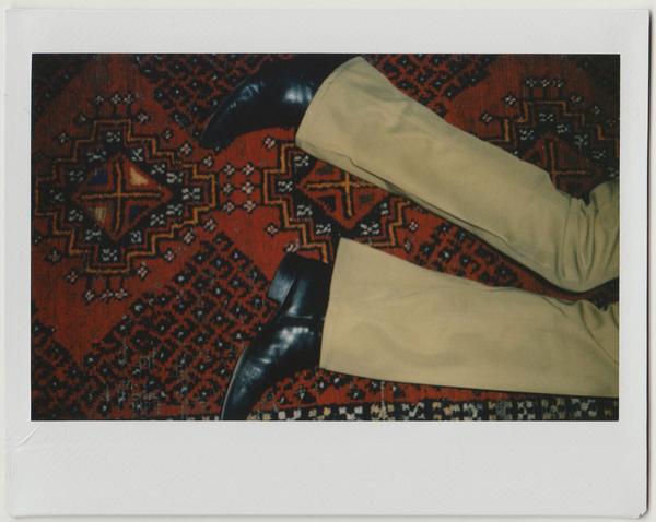 detail of pants, boots on carpet. 