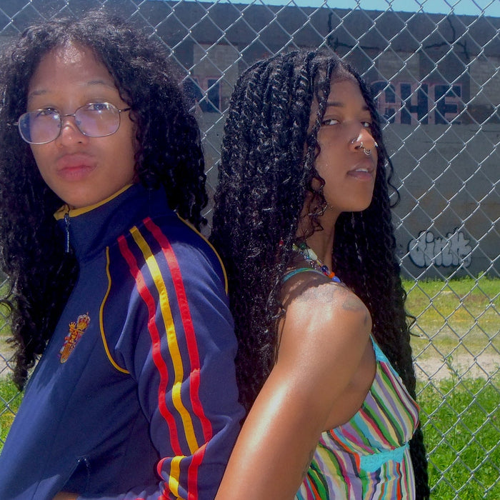 two people posing in front of chainlink fence