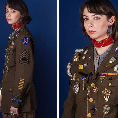 model wearing military blazer and a lot of rings, brooches and pins. 