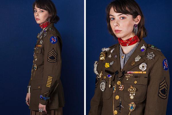 model wearing military blazer and a lot of rings, brooches and pins. 