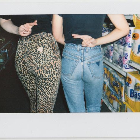 shot of alta and rachel's backs with fingers crossed behind their backs. 