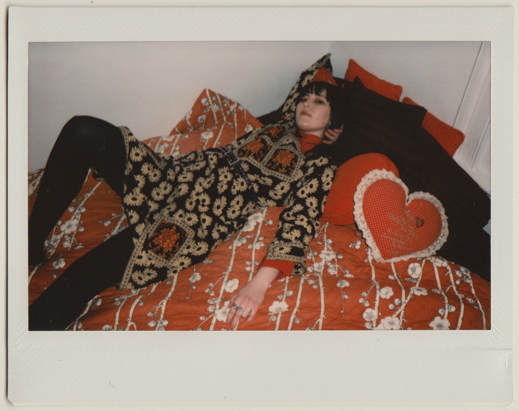 ashley posing on bed spread in vintage piece. 