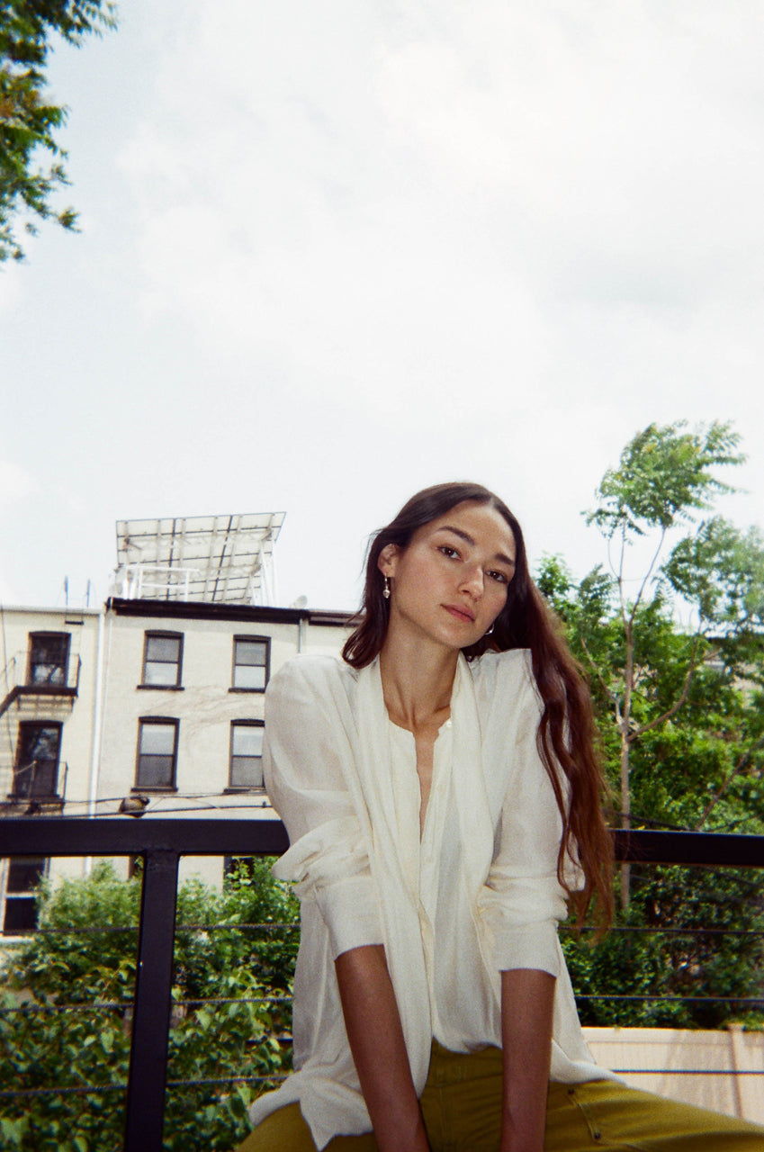 bruna seated on balcony posing.