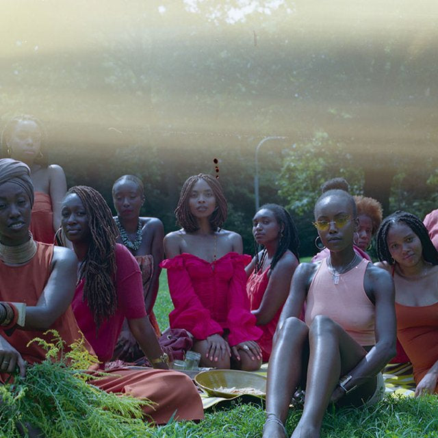  mel chanté and friends seated on a lawn, still from music video. 
