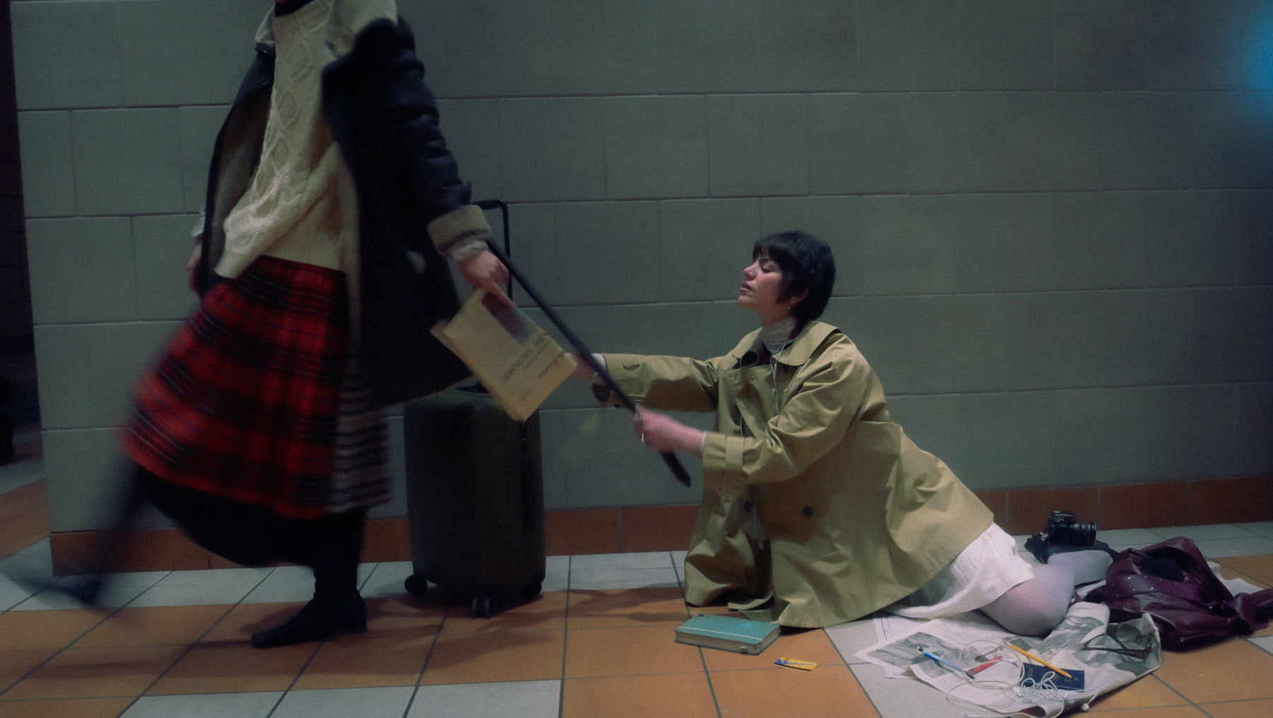 one person holding a suitcase bag and other person is holding on the suitcase bag on the floor. both dressed nicely