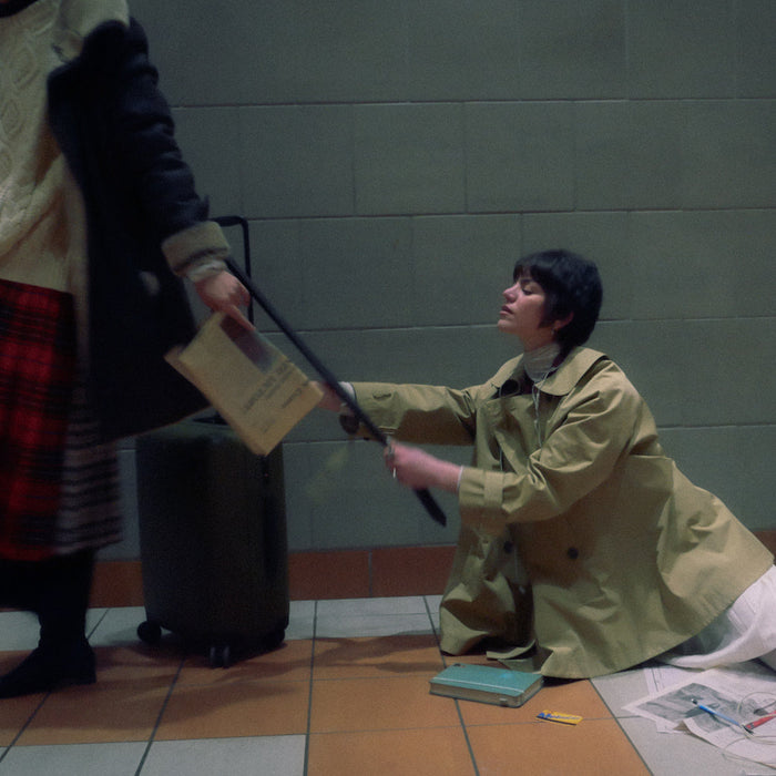 one person holding a suitcase bag and other person is holding on the suitcase bag on the floor. both dressed nicely