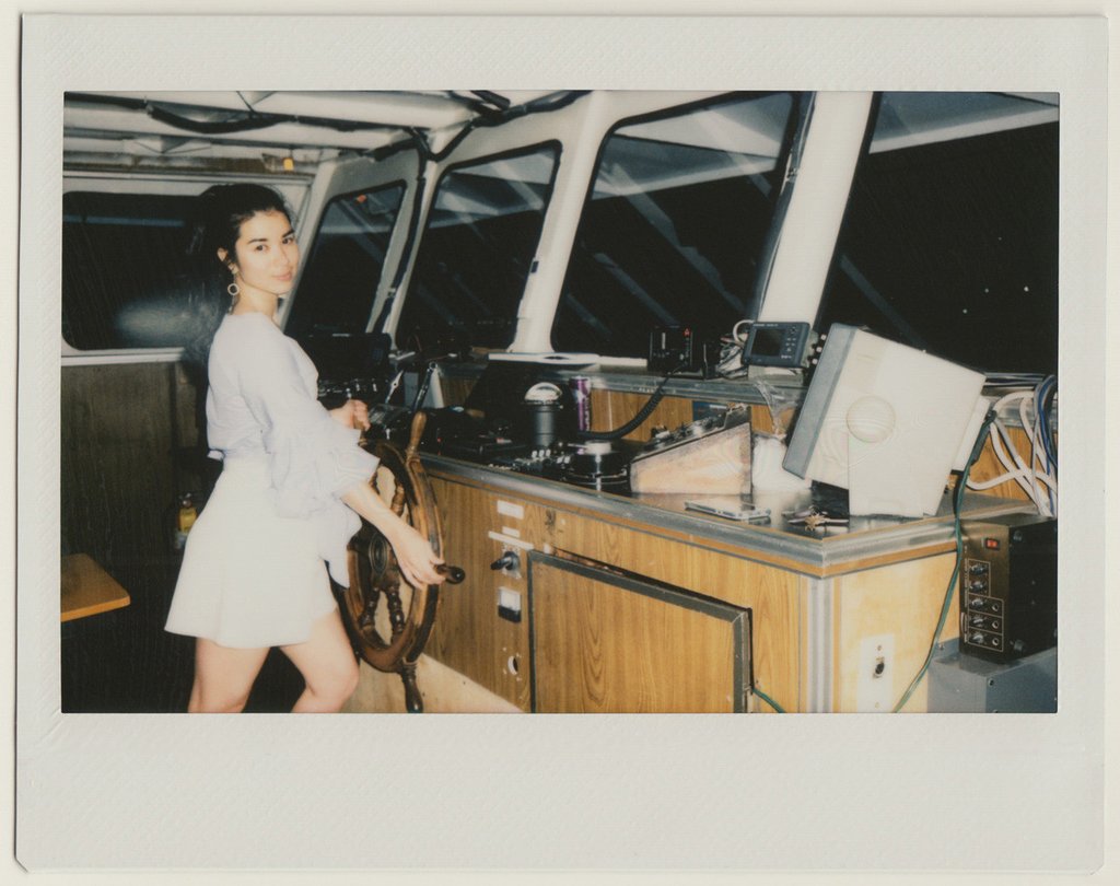 model posing at the boat's steering wheel.