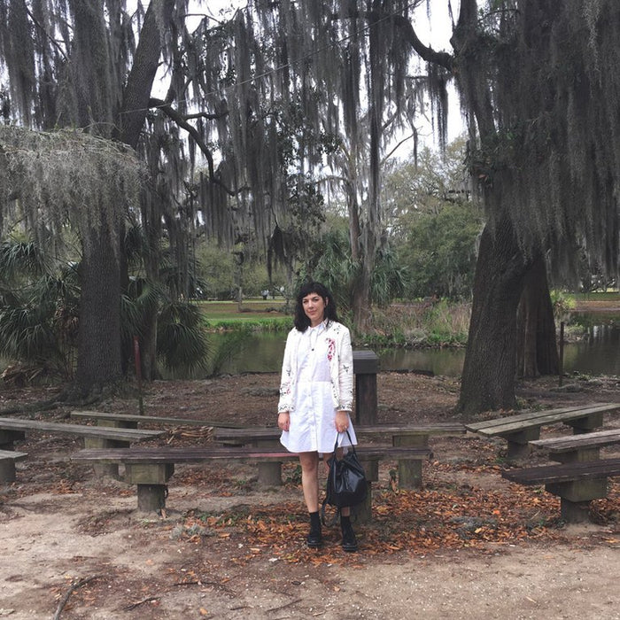 a person standing next to a bench in a park.