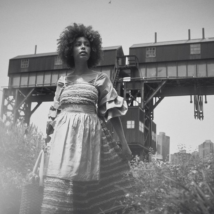 model posing with flowers and industrial structure. 