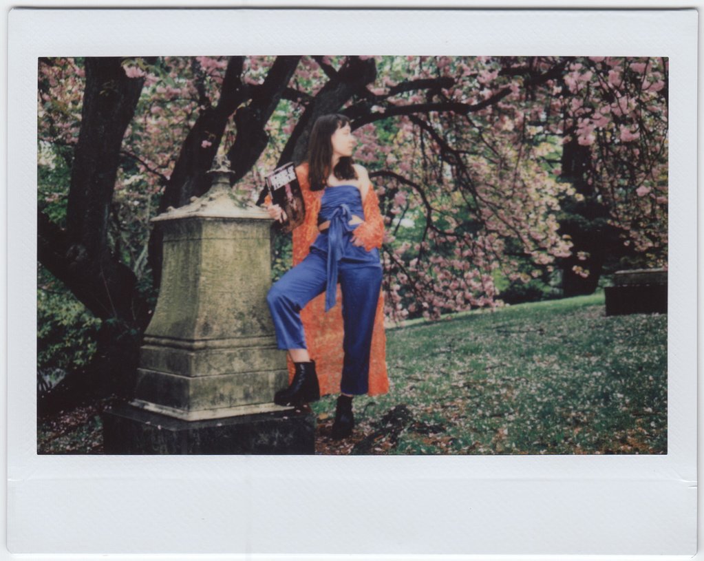 susy in jumpsuit and trench coat in the park. 