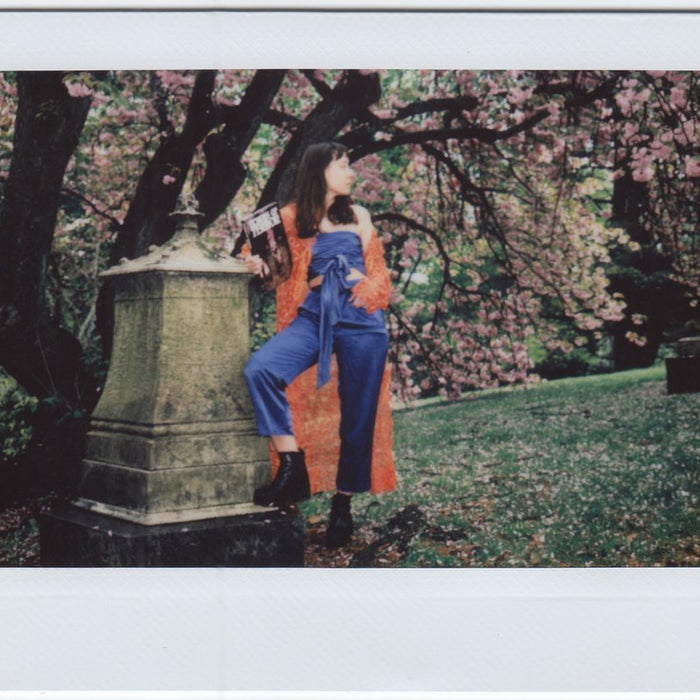 susy in jumpsuit and trench coat in the park. 