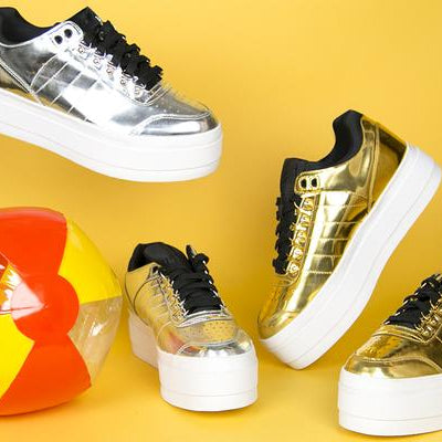 still life featuring beach ball and metallic platform sneakers. 