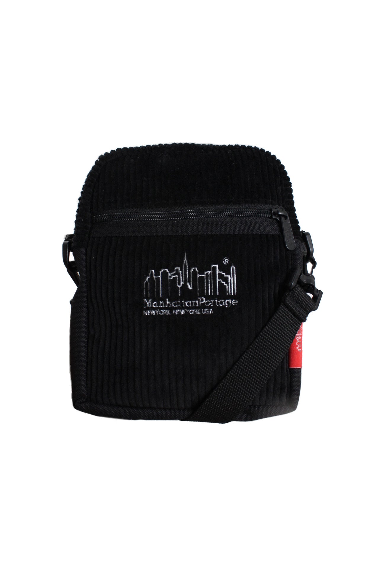 front view of the manhattan portage x brisbane moss black corduroy cross body bag. features top zip main compartment, front zip slot pocket, adjustable/removable shoulder strap, ‘manhattan portage new york new york usa’ logo embroidered at front side, ‘brisbane moss jine quality fabrics tradition in unison’ logo tab at back side, and ‘manhattan portage’ logo tab at side.