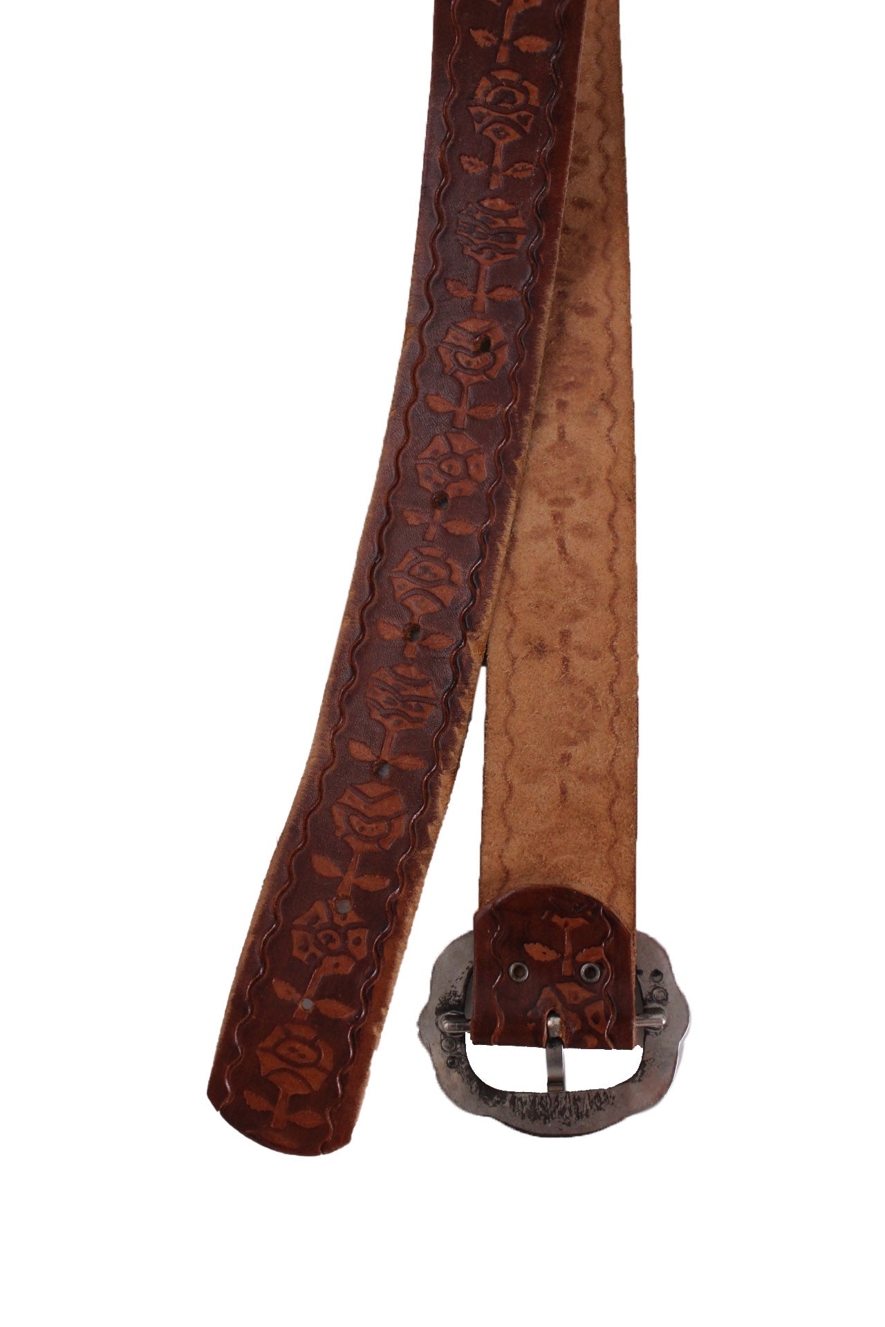 elevated angle of buckled portion interior & 6-hole portion exterior of vintage brown toned tooled leather belt.
