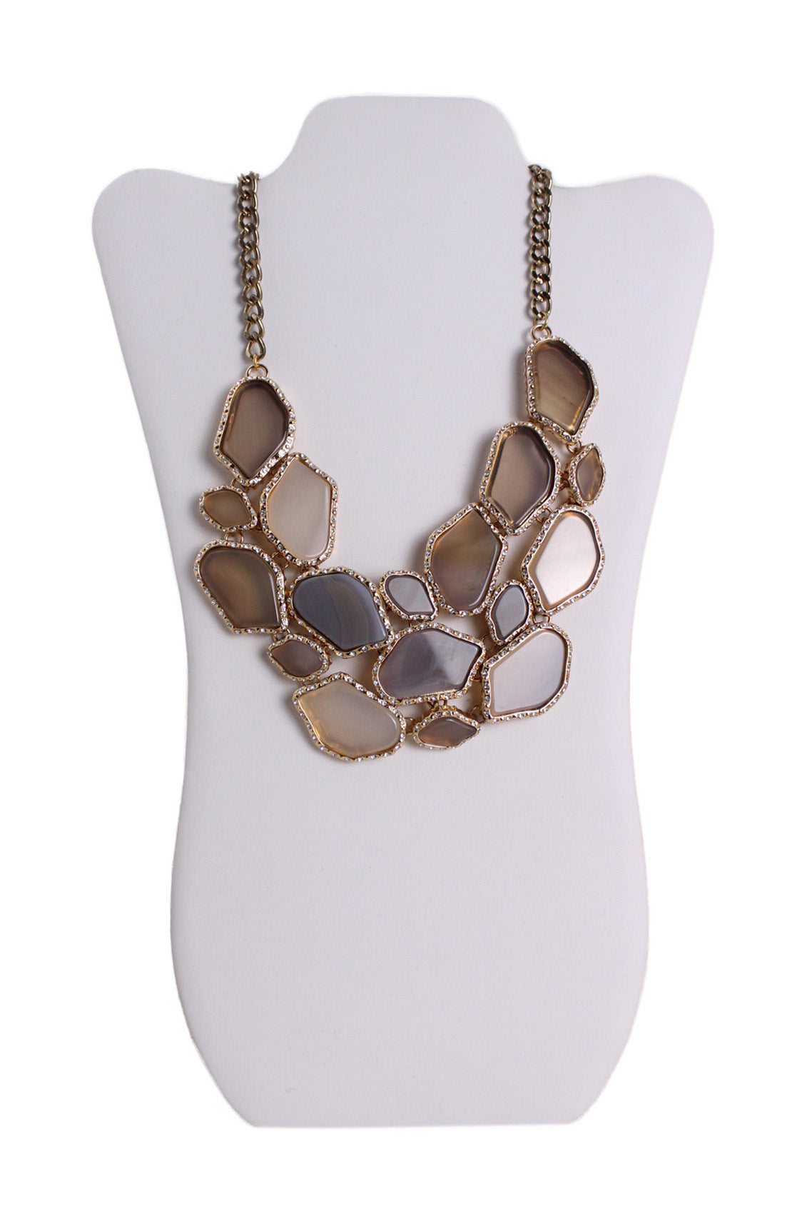 front of bcbg maxazria gold toned with stones necklace. features geometrical shapes laced in stones, and rhinestones all over.