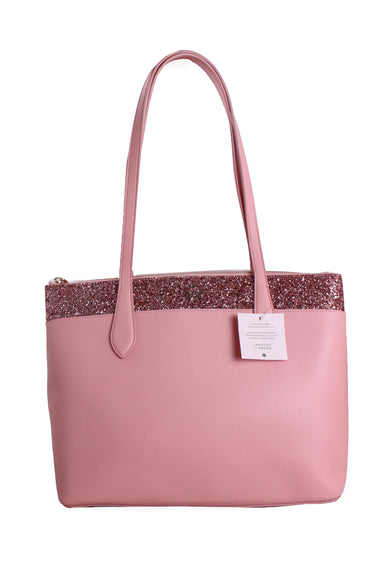 front of  kate spade pink maxi tote bag. features shoulder straps, glitter strap detail at top, gold toned hardware, gold logo brand pin at front, and zip closure. 