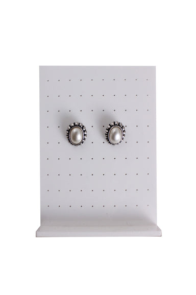 silver toned metallic earrings set against an earrings stand
