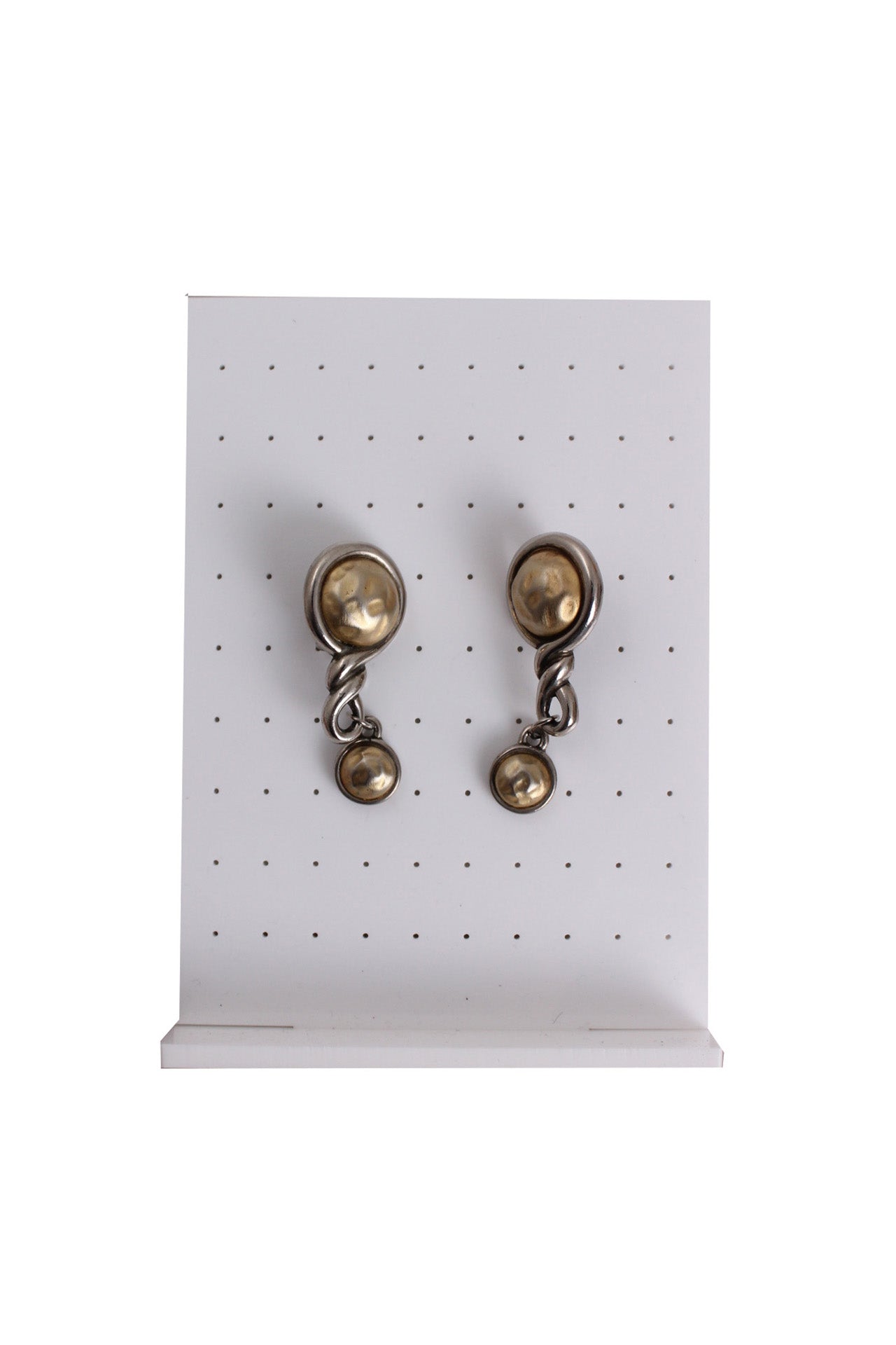 aged silver and gold toned chunky knot-like earrings staged against earring stand.