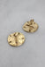 ¾ top view of the back of rounded clip-on earrings showcasing hinge style backs. 