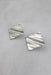 ¾ top view of silver earrings with wavy rippled effect.