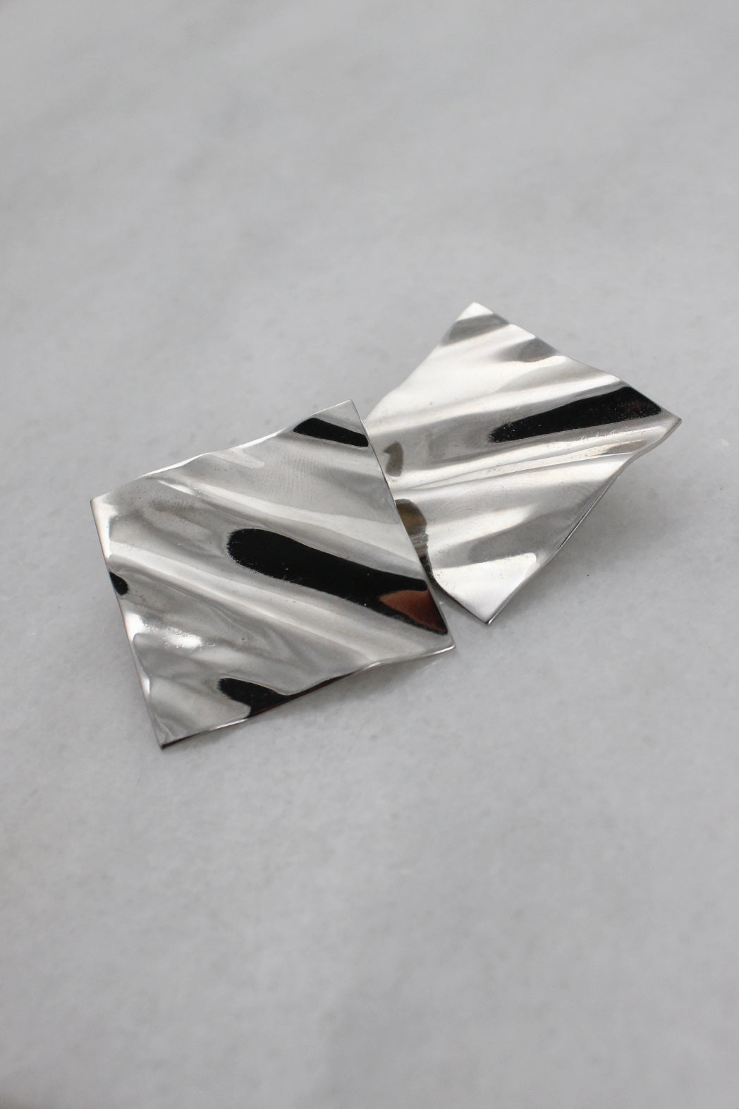 ¾ front of silver earrings laid on each other