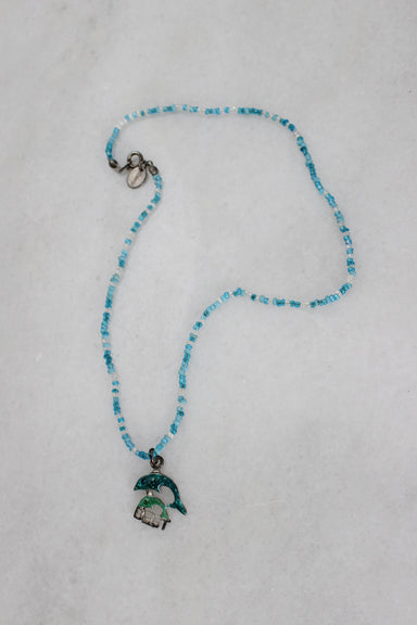above angle of necklace with dolphin pendant. 