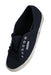 ¾ top view of navy sneakers with branded insoles and tonal laces.