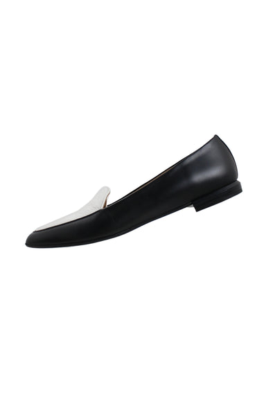 profile of everlane b&w leather flats. features tapered toe, panel in white at vamp, heels measuring ~0.6", and slip on fit. 