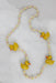 unlabeled multicolor pearl necklace. features 4 wooden ducks and peach, yellow, and white pearls of varying sizes. 