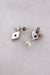 ¾ angled top view of silver backed heart and diamond shaped earrings with branded holes and butterfly style backs laid flat upside down.