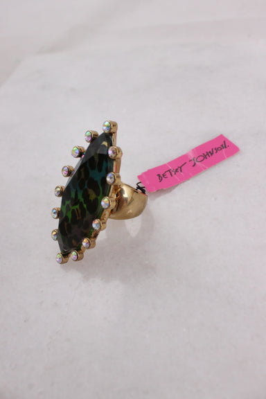 ¾ angled profile of gold toned metallic ring with original tagged attached that reads ‘betsey johnson’