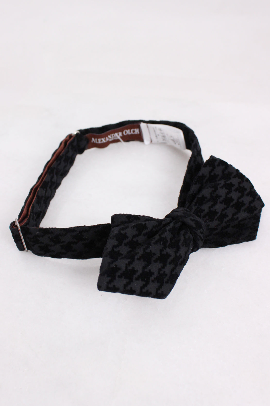 upper angle of bowtie. features adjustable width and branded care tag with text 'alexander olch'. 