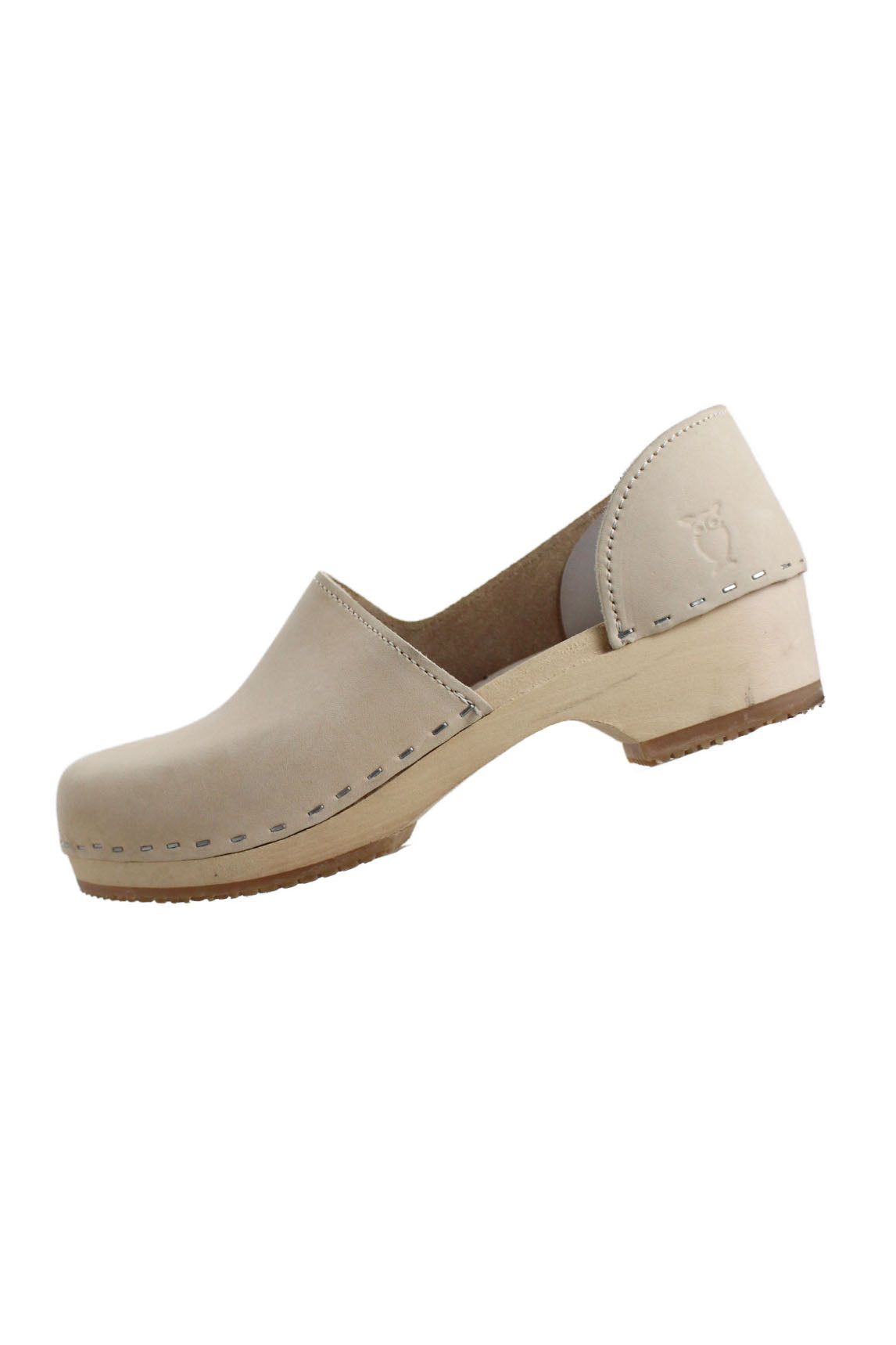 profile of sandgrens beige heeled clogs. features contrast stitching, rounded toe, embossed logo brand at outer side, rubber sole, and slip on style. 