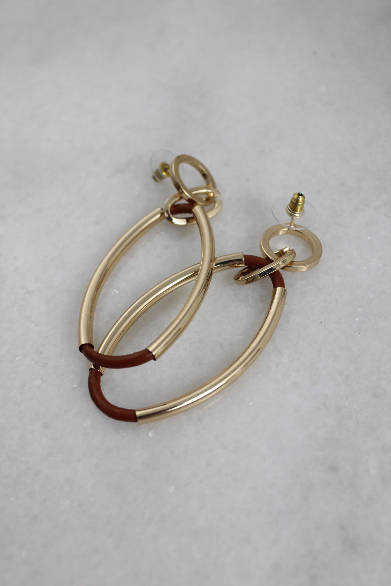 angled top view of hoop earrings laid flat upside down showcasing the push style backs. 
