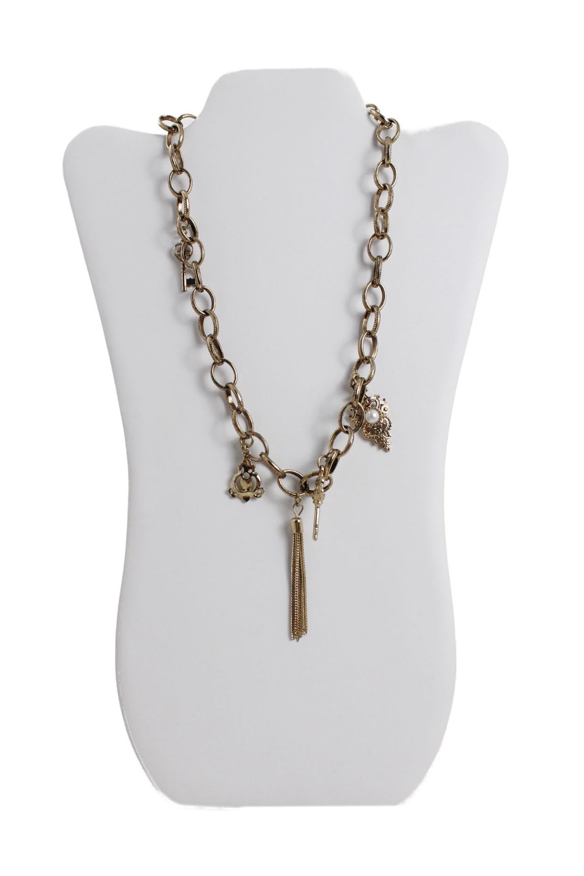 front of vintage gold toned chain link necklace. features multiple  keys/ tassel/abstract charms, and maxi spring ring closure.