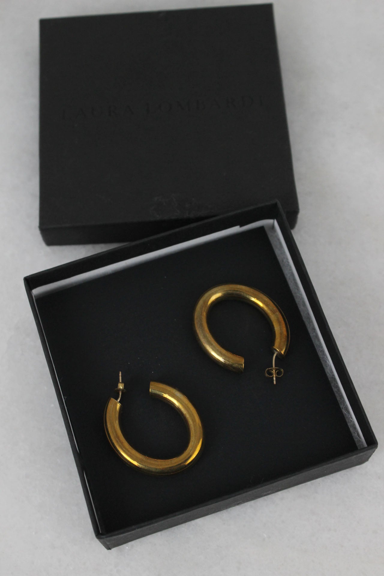 detailed shot of brass earrings in black box. 