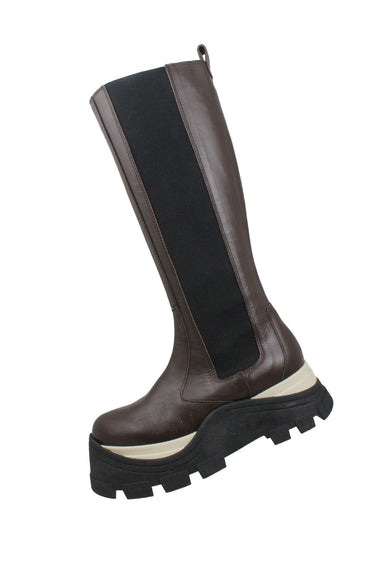 profile of alohas brown leather tall chunky platform boots. brown leather upper with elastic side panels for added stretch. no closure, pull-on style. black/white sporty chunky 2.5" platform soles with toothed tread. 