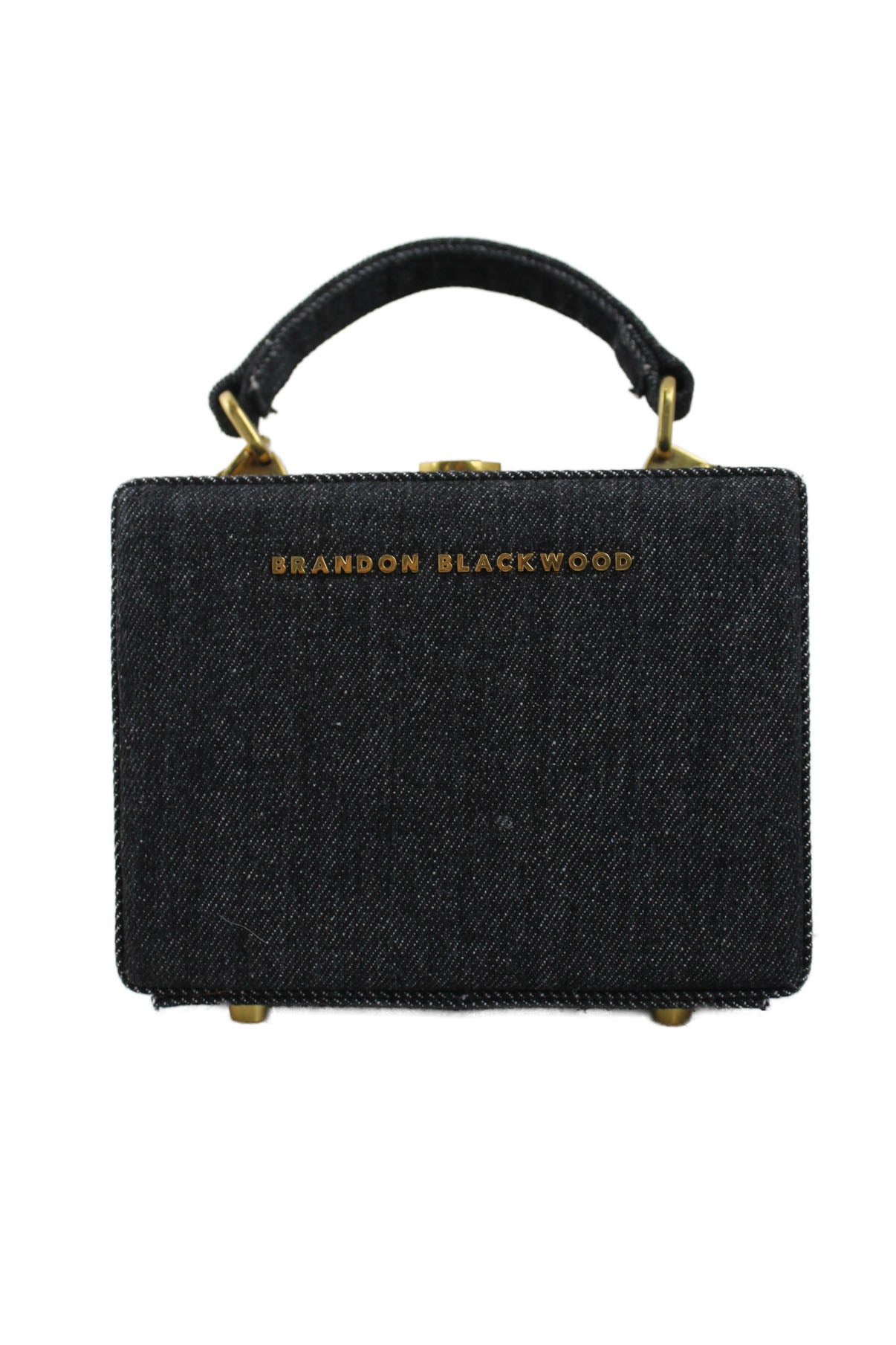 front of brandon blackwood dark denim trunk bag. features square shape, gold toned hardware, adjustable strap, and lock clasp closure. 