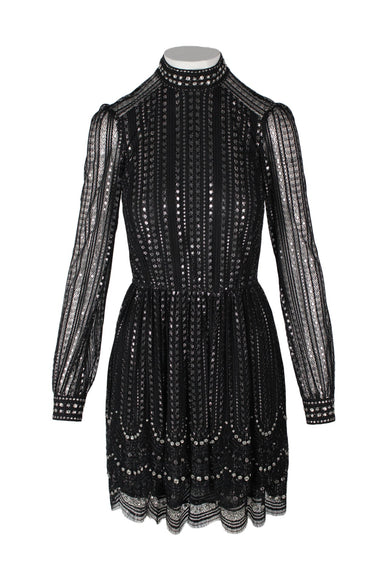 front angle michael by michael kors black and silver long sleeve lace mini dress on feminine mannequin. silver metallic dotted fabric, sheer sleeves, stand-up collar, tiered lower with clear rhinestone embellishment, scalloped hem.