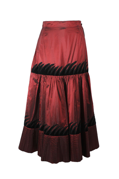 front of vintage oddio red metallic maxi skirt. features black velvet abstract design, high waist, tiered design, and iridescent finish.