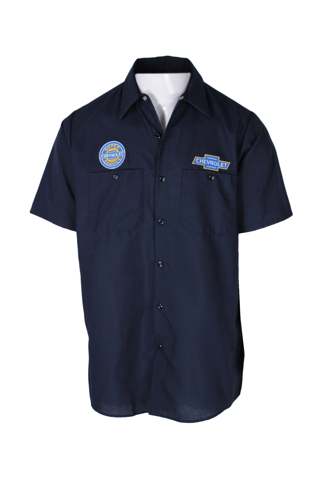 front angle of vintage red kap dark blue chevrolet service shirt on masc mannequin torso. features short sleeves, button closure up center, two buttoned breast pockets, pointed collar, and branded embroidered patches over pockets with text 'chevrolet super service' and 'chevrolet'. 
